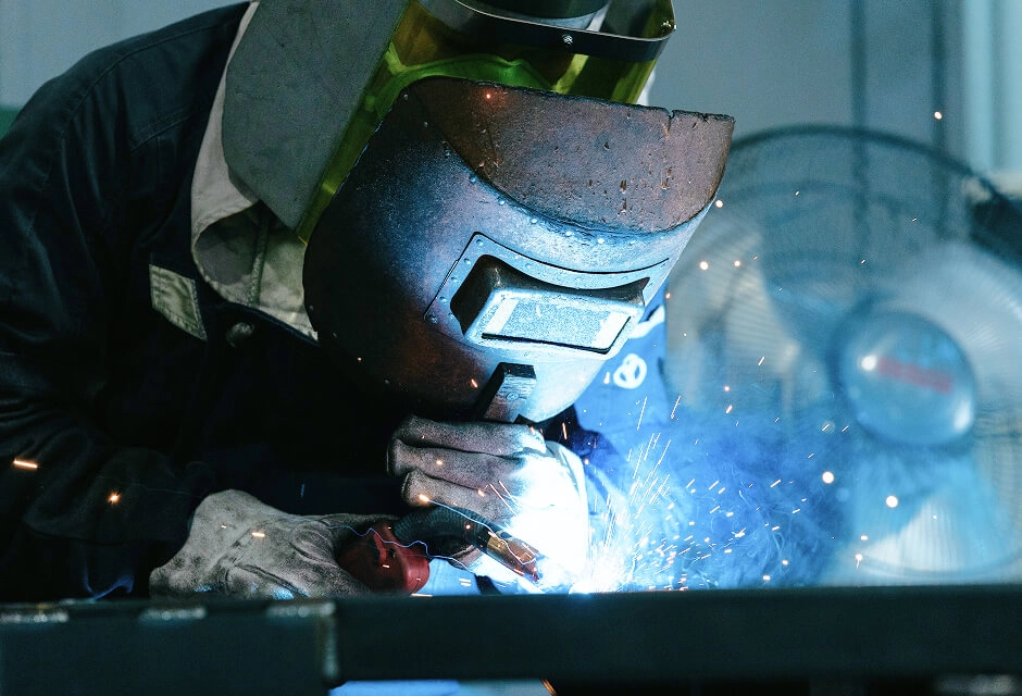 金属部品の溶接作業を行っている製造スタッフ