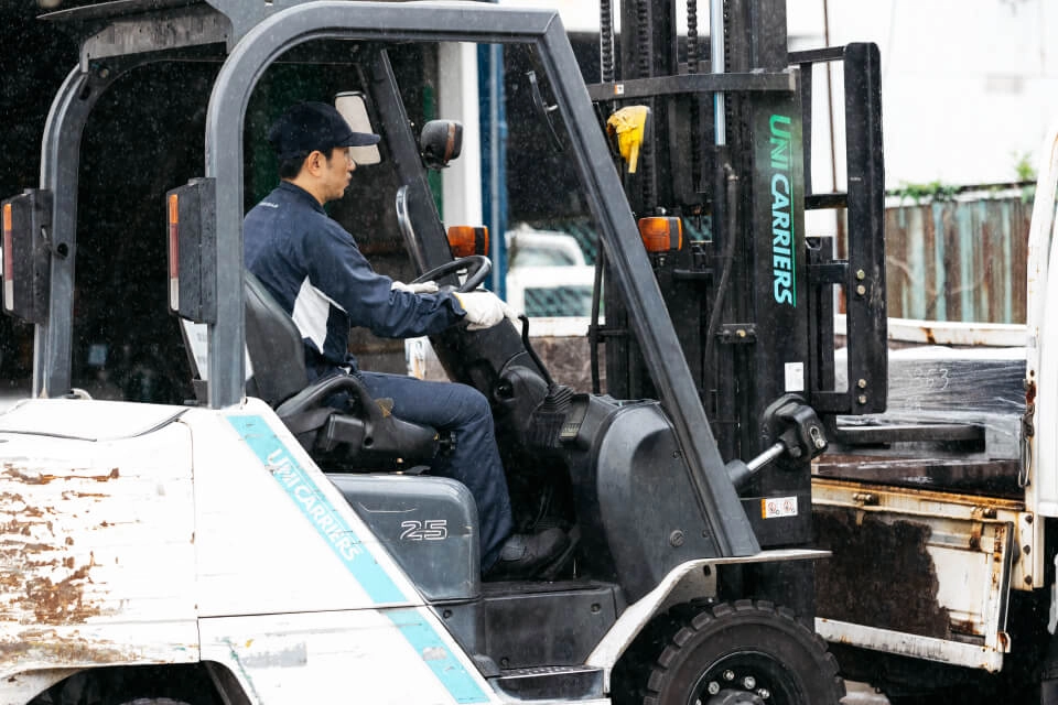 フォークリフトを操作して製品を搬送している作業員