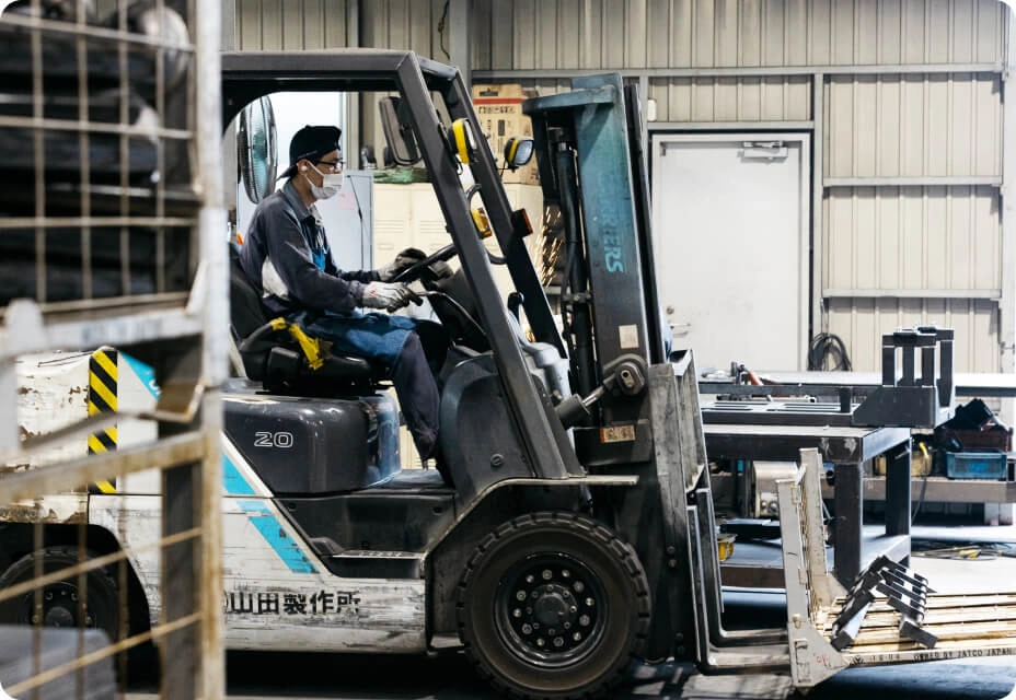 工場内でフォークリフトを操作する作業員