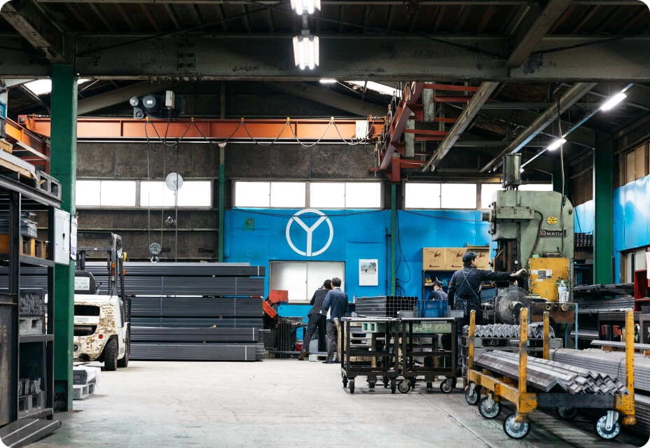 工場内で設備や台車を使用して作業を行う作業員