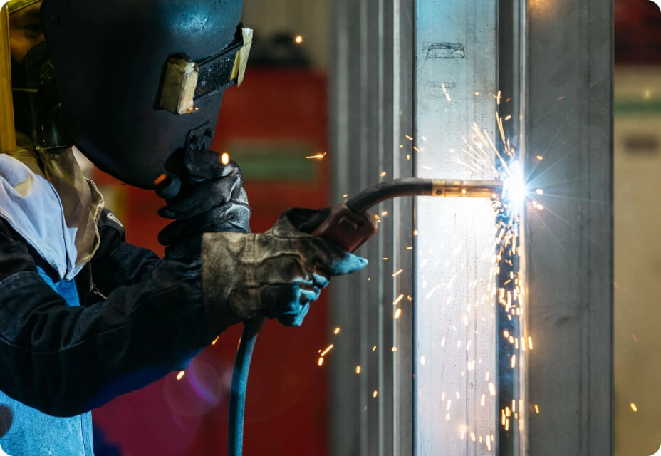 作業員が工場内で溶接作業を行っている様子