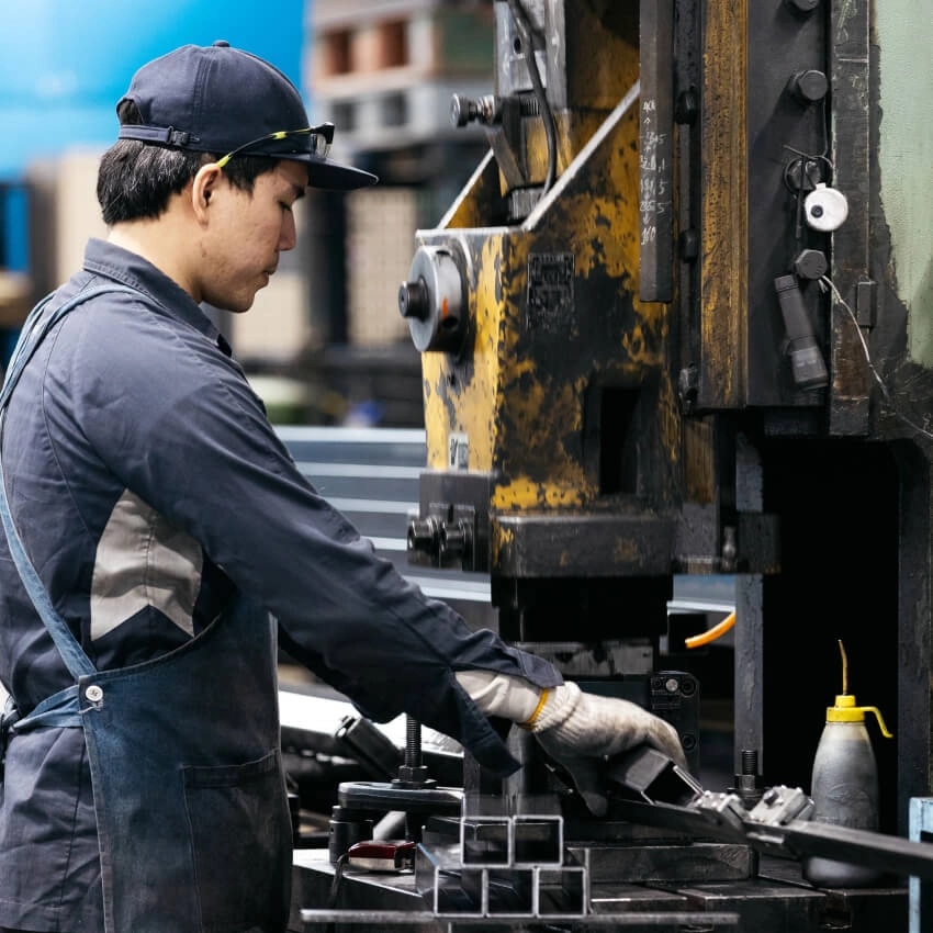 工場内で機械を操作しながら製品加工を行う製造スタッフ