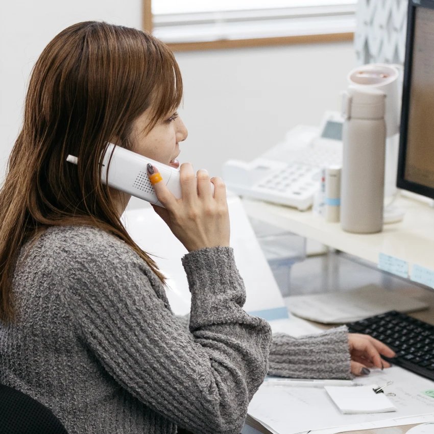 オフィスで業務調整の電話対応を行う管理スタッフ