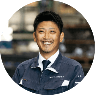 工場内で作業着を着た笑顔の男性