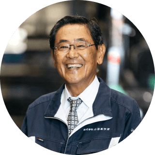 工場内で作業着を着た笑顔の男性