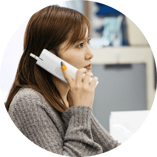 オフィス内で電話をかけている女性