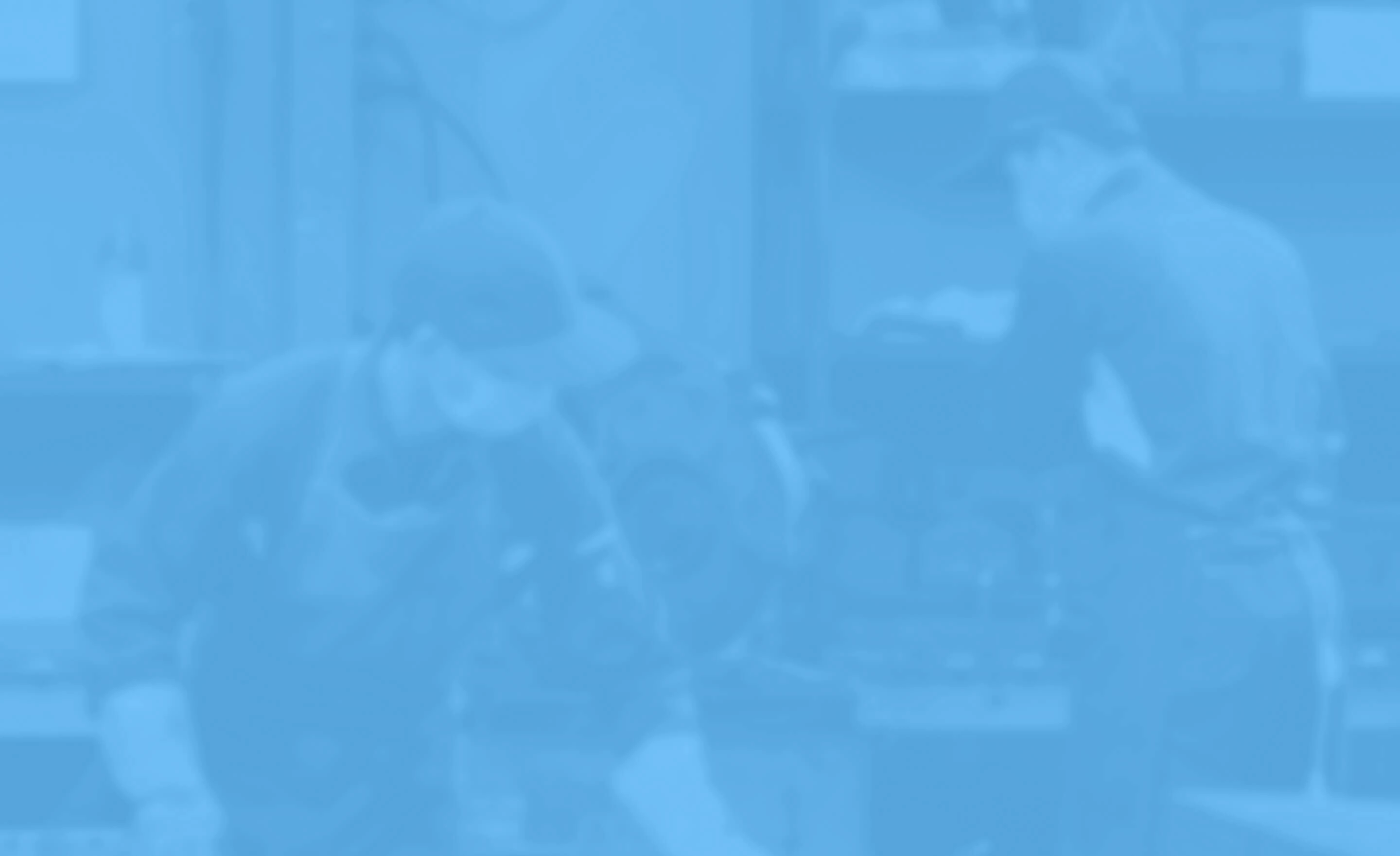 工場内で作業着を着た複数の人物が製造作業をしている様子